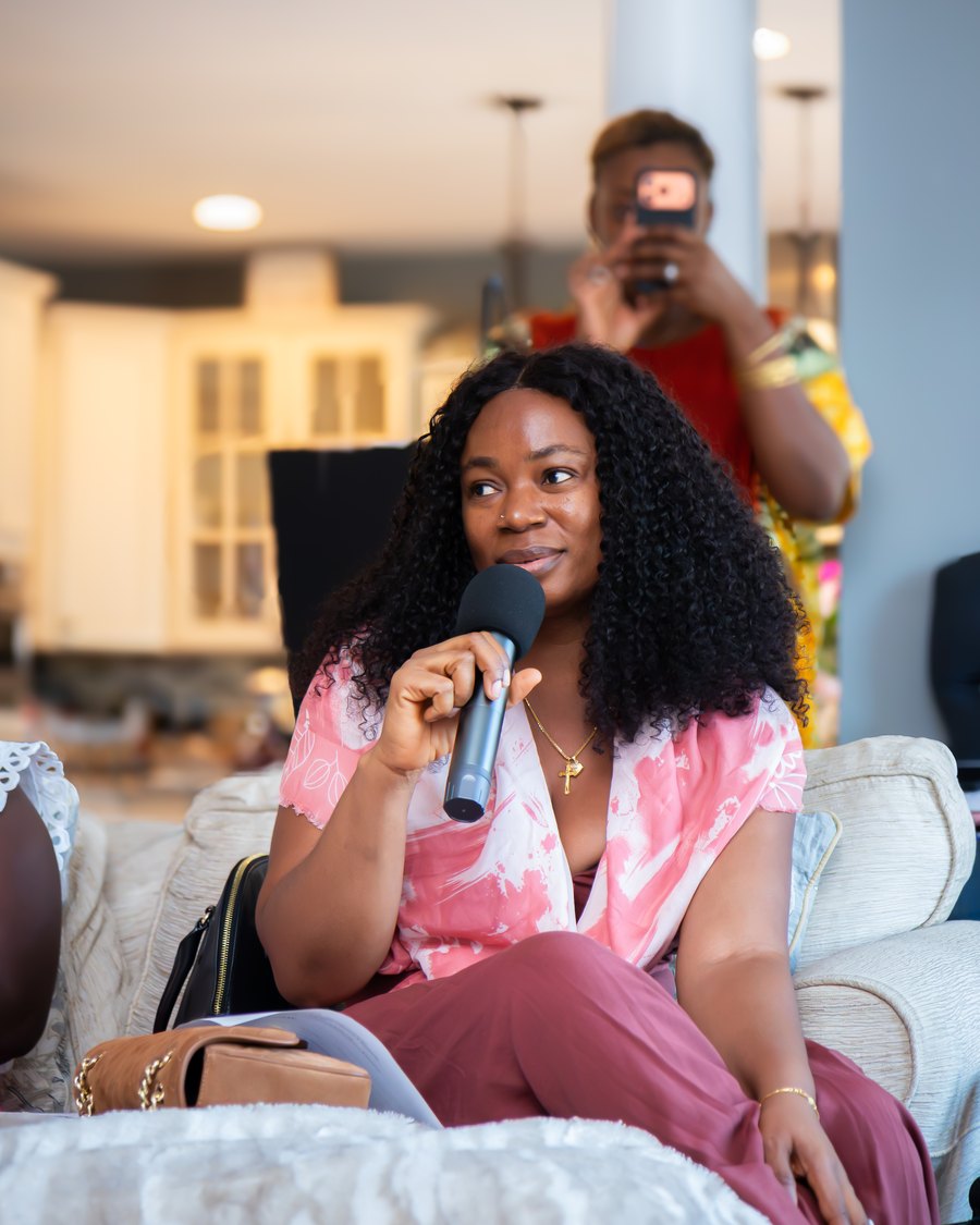 A woman speaking into a microphone at The MEND Experience
